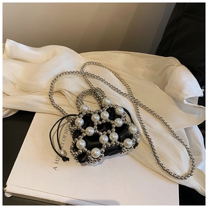 Dettaglio mini borsa in raso nero con perle bianche intrecciate e rete metallica