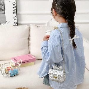 Silver quilted girls crossbody bag with bow decoration and gold chain strap