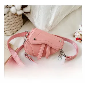 Détail du sac selle rose en cuir texturé avec bandoulière en chaîne argentée