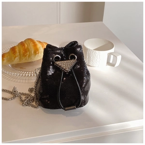 Détail du mini sac seau en paillettes noires avec un pendentif triangle en cristal