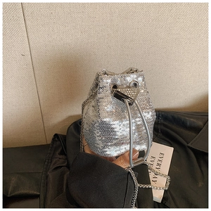 Détail du sac seau à paillettes argentées avec bandoulière chaîne et fermoir triangle