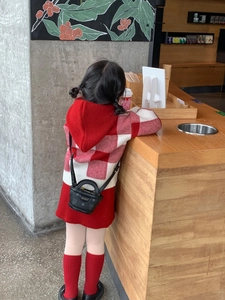Detailed back view of a red plaid knitted hooded dress with matching socks and mini bag