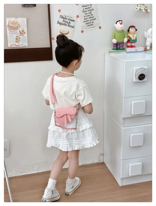 Détail de mini sac selle rose pour filles avec bandoulière et pompon décoratif