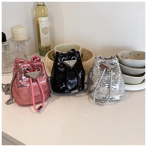Détail des sacs seaux à paillettes en rose, noir et argent avec bandoulière chaîne