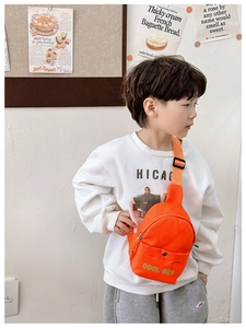 Detailaufnahme der hellorangen Nylon-Kindertausche mit grünem COOL BOY-Aufdruck