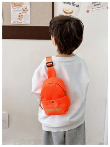 Detail der orangefarbenen Kinder Brusttasche mit COOL BOY Logo und Trageriemen