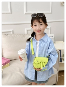 Détail du sac selle jaune néon pour enfants avec chaîne en métal et lanières en cuir