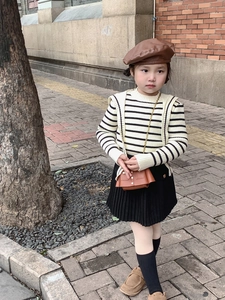 Détail d'un ensemble en tricot vintage pour enfant avec béret marron et petit sac