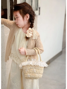 Détail du sac seau en paille avec bordure en dentelle délicate et nœuds pour filles