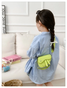 Détail du sac selle enfant vert néon avec texture grainée et bandoulière en chaîne