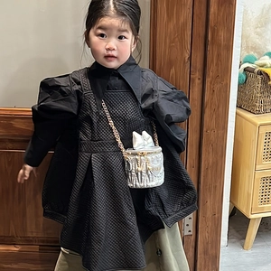 Sac seau argenté avec chaîne cœur dorée porté par un enfant en robe noire matelassée