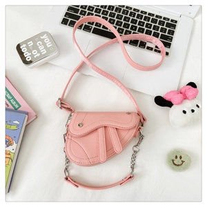 Vue détaillée du sac selle rose en cuir synthétique avec chaîne argentée et sangle