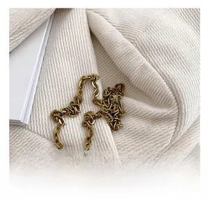 Détail de la chaîne en métal doré sur tissu en velours côtelé blanc pour sac enfant