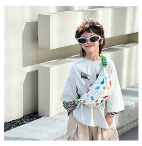 Close-up of cute cartoon dinosaur print nylon waist bag with adjustable green strap