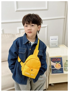 Junge in Jeansjacke trägt gelbe Nylon-Brusttasche mit COOL BOY Schriftzug