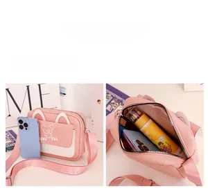 Détail du sac à bandoulière rose avec intérieur spacieux et design d'oreilles de chat