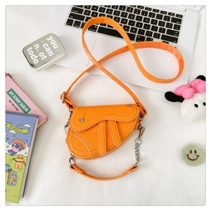 Vue détaillée du sac selle orange avec texture grain litchi et chaîne en métal argenté