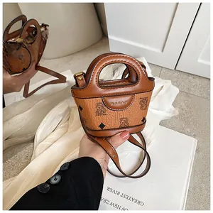 Detail of mini brown PU crossbody bag featuring cute cartoon bear prints and gold MARAH logo