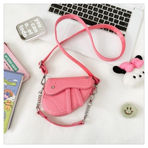 Vue détaillée d'un mini sac selle rose avec texture grainée et bandoulière en chaîne