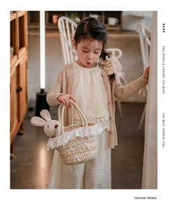 Détail de la broderie en dentelle et du cardigan tricoté pour bébé en vue