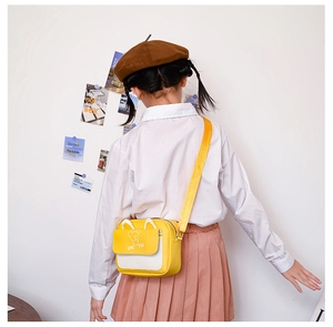 Détail d'un petit sac bandoulière jaune pour enfant avec motif ours vu de côté