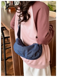 Detail of vintage denim hobo crossbody bag with wide strap and minimalist design