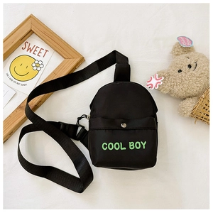 Detailansicht der schwarzen Kinder-Brusttasche mit grünem COOL BOY-Text und Schnalle