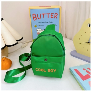 Detailansicht der grünen Kindertasche mit orangefarbenem COOL BOY Aufdruck und Vordertasche