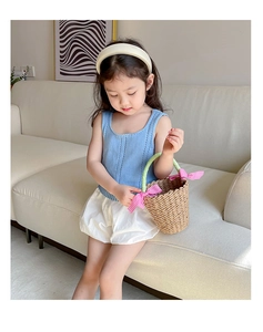 Kids summer outfit with blue knit vest, puffy shorts and woven basket with pink bow