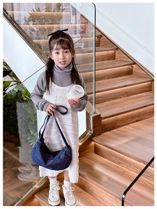 Detail of dark blue denim hobo bag for kids featuring wide strap and metal zipper
