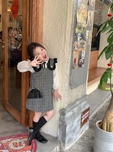 Détail d'un mini sac bandoulière créatif en forme de veste avec une robe rétro pour fille