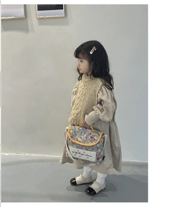 Detail of floral kids crossbody bag with yellow piping and custom brand label