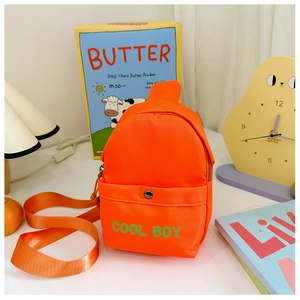 Detail der leuchtend orangen Kinder-Brusttasche mit grünem COOL BOY-Druck und Tasche