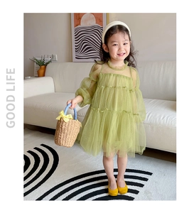 Detail of avocado green toddler tulle dress with layered skirt and puff sleeves in a home setting