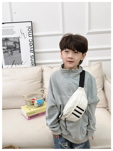 Detail of white canvas kids chest bag featuring black stripe design and nylon strap
