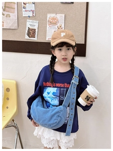 Detail view of adjustable denim crossbody bag for kids with metal buckle and strap eyelets