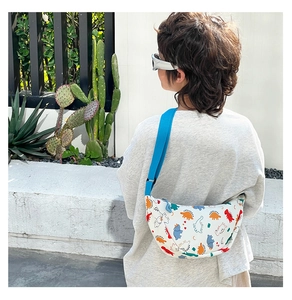 Outdoor shot of a child wearing a white nylon chest bag with colorful dinosaur prints