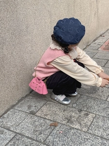 Fille portant un mini sac bandoulière rose en forme de veste et un béret en jean