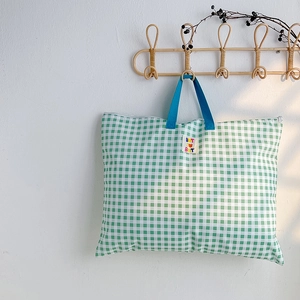 Détail du sac cabas enfant à carreaux verts avec poignées bleues et écusson de lettres
