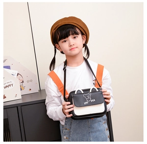 Détail d'un petit sac bandoulière bicolore avec un motif koala mignon porté par l'enfant