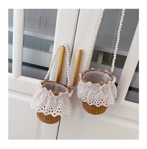 Detailed view of woven straw bucket bag with elegant lace trim and white pearl handle