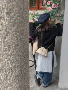 Fille portant un sac bandoulière beige créatif en forme de veste avec chaîne dorée