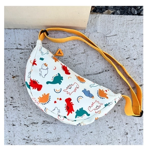 Close-up of kids dinosaur print crossbody bag with yellow strap on gray background