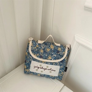 Detail of blue floral kids crossbody bag with small flowers and adjustable cream strap