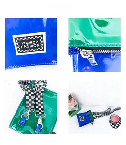 Détail du sac bandoulière en cuir verni bleu et vert avec sangle à damier noir