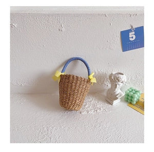 Close-up of handmade straw tote bag with blue checkered handle and yellow bows