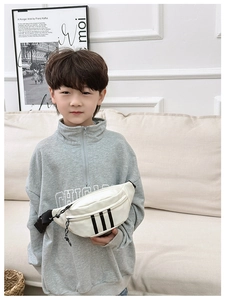 Detail of white kids waist bag featuring three black stripes and adjustable nylon strap