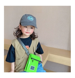 Détail du sac enfant vert néon en cuir verni avec bandoulière à damier tendance