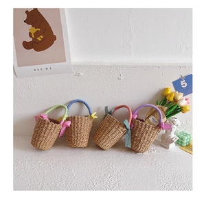 Detail of four handmade straw bags with colorful checkered handles and ribbon bows