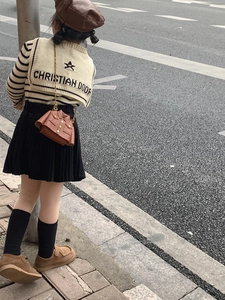 Détail d'un mini sac bandoulière créatif en forme de veste pour enfant avec tenue chic